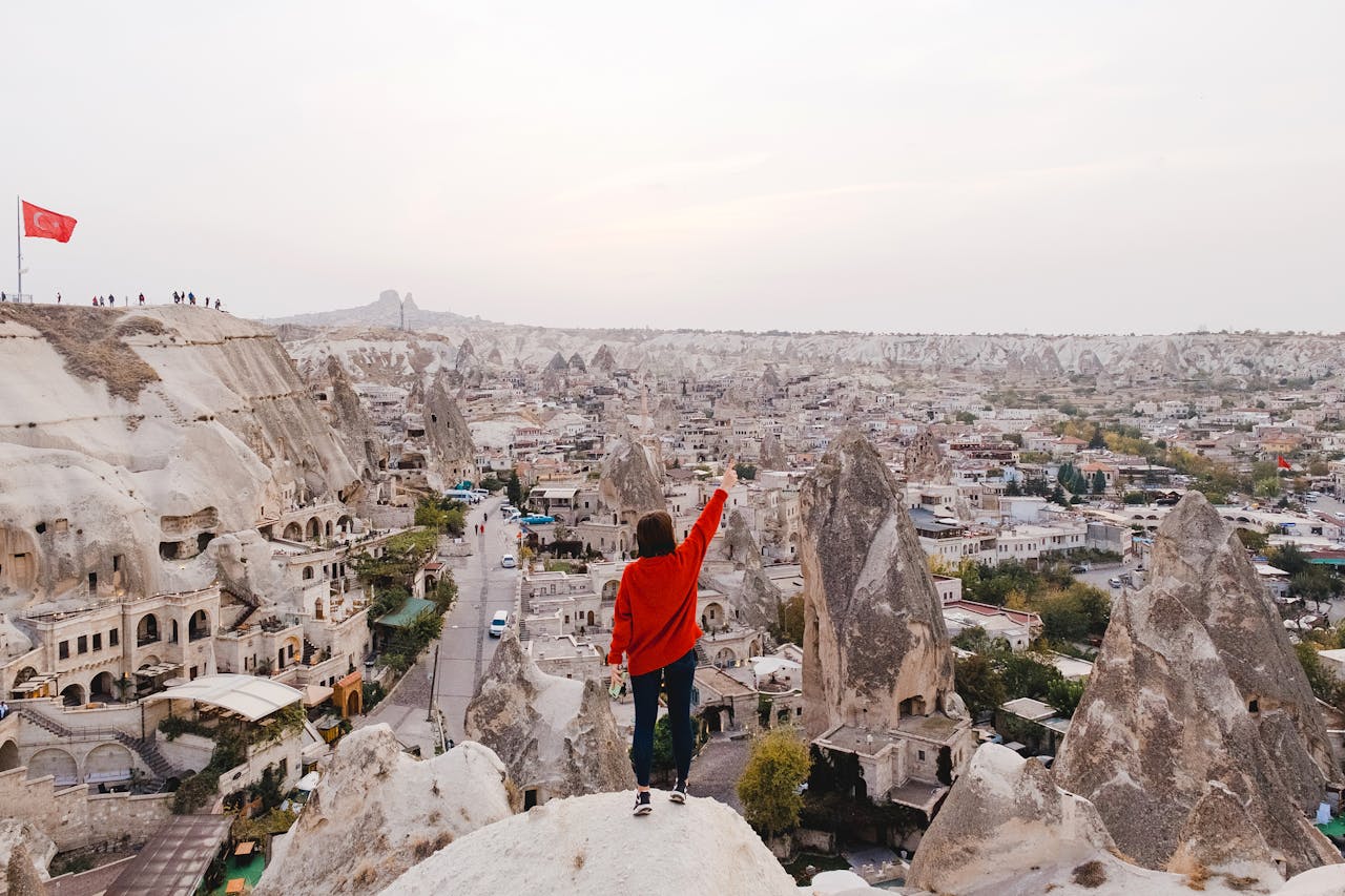 Explore the stunning rock formations of Cappadocia, Turkey with a traveler enjoying a panoramic view.